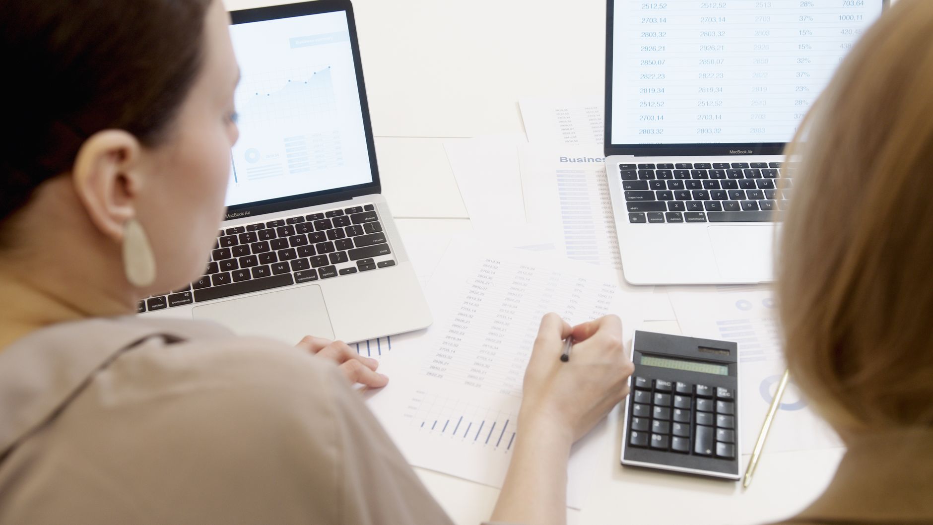 A pay and reward manager reviewing a pay band sheet with a colleague before the salary review